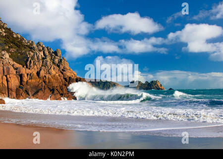 Una vista della spiaggia di porthcurno come onde infrangersi contro le scogliere Foto Stock