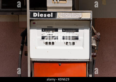 Vecchio diesel pompa benzina in Austria. Stazione di riempimento nella parte anteriore del colore rosa house. Avvertenze in tedesco per la sicurezza del rifornimento: arrestare il motore, senza aprire il fuoco. Foto Stock