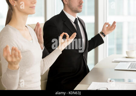 Imprenditore e imprenditrice meditando a scrivania da ufficio, corpora Foto Stock