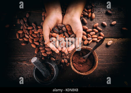 Mano azienda arrosto di fave di cacao, vista dall'alto Foto Stock