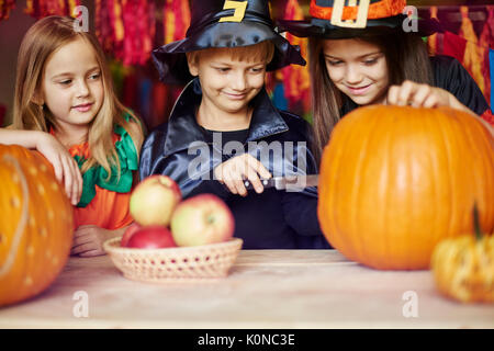 Intagliare una zucca è un dovere del ragazzo Foto Stock