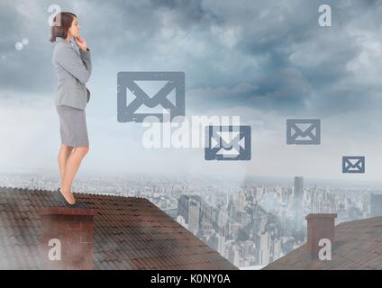 Composito digitale delle icone di posta elettronica e imprenditrice in piedi sul tetto con camino e nuvoloso city Foto Stock