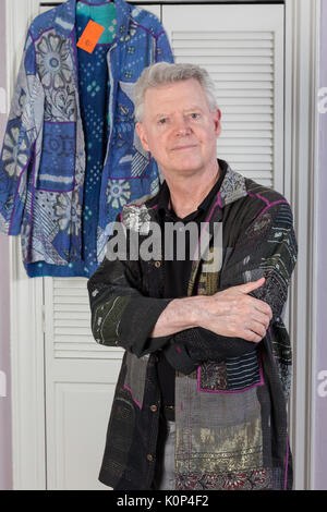 Senior uomo cercando sulla camicia di designer in spogliatoio, NYC, STATI UNITI D'AMERICA Foto Stock