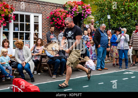 La popolazione locale "howjumping' con un cavallo giocattolo all annuale South Street la giornata dello sport e Dog Show, Lewes, East Sussex, Regno Unito Foto Stock