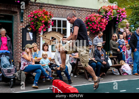 La popolazione locale "howjumping' con un cavallo giocattolo all annuale South Street la giornata dello sport e Dog Show, Lewes, East Sussex, Regno Unito Foto Stock