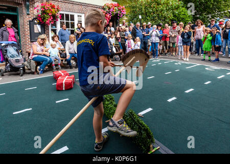 La popolazione locale "howjumping' con un cavallo giocattolo all annuale South Street la giornata dello sport e Dog Show, Lewes, East Sussex, Regno Unito Foto Stock