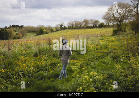 Vista posteriore della donna che cammina nel bosco su una giornata di sole Foto Stock