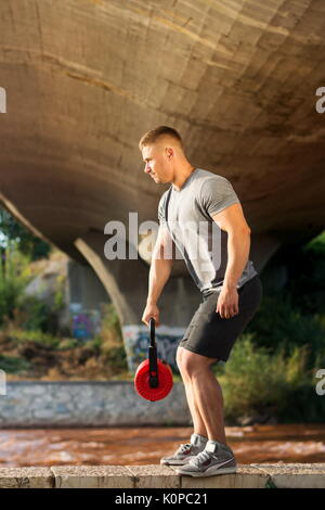 Uomo che lavora fuori sotto il ponte all'aperto Foto Stock