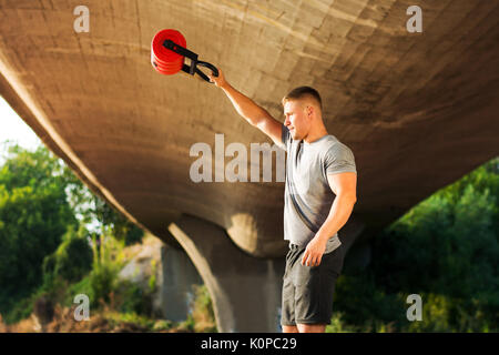 Uomo che lavora fuori sotto il ponte all'aperto Foto Stock