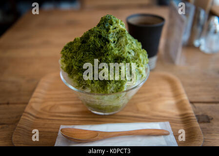 Tè verde giapponese rasato ghiaccio su un vassoio di legno e tè caldo Foto Stock