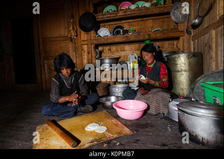 Il Tibetano madre e figlio momos cottura, il tipico gnocco tibetano, a casa Kham, Tibet Foto Stock