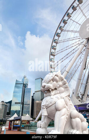 Un Cinese tradizionale custode lion statua con Hong Kong skyline al Central Pier, sul Porto Victoria sull isola di Hong Kong. Comune e popolare nella lombata Foto Stock