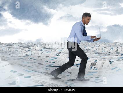 Composito Digitale di imprenditore su laptop in mare di documenti sotto le nuvole del cielo Foto Stock