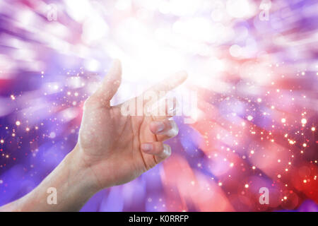 Mano di uomo fingendo di toccare una schermata invisibile contro lo sfondo incandescente Foto Stock