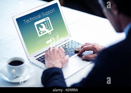 Supporto tecnico il testo con lo strumento contro l uomo d affari usando il suo computer portatile presso il ristorante Foto Stock