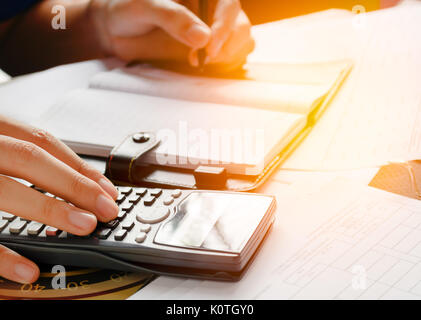 Close up, uomo d affari o un avvocato ragioniere lavorando su account utilizzando una calcolatrice e scrivere su documenti, soft focus Foto Stock