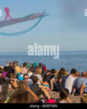 La folla si impacchera sulla spiaggia in una serata gloriosa per la visualizzazione delle frecce rosse, che segnala l'inizio della regata di Sidmouth. Foto Stock