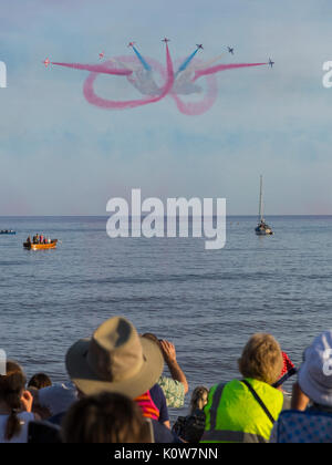 La folla si impacchera sulla spiaggia in una serata gloriosa per la visualizzazione delle frecce rosse, che segnala l'inizio della regata di Sidmouth. Foto Stock