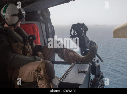 Golfo Arabico (Agosto 16, 2017) Aircrewman navale (elicottero) 1a classe Timoteo Igoe, da Houston, mans un 0,50 Caliber machine gun all'interno di un MH-60S Sea Hawk elicottero assegnato alla â€oeEightballersâ€ di elicottero di mare squadrone di combattimento (HSC) 8 imbarcato a bordo della portaerei USS Nimitz CVN (68). Nimitz attualmente distribuito negli Stati Uniti Quinta Flotta area di operazioni a sostegno di funzionamento inerenti a risolvere. Mentre nella regione, la nave e strike gruppo stanno conducendo le operazioni di sicurezza marittima per rassicurare gli alleati e partner, preservare la libertà di navigazione e di mantenere il libero flusso di co Foto Stock