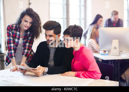 Un gruppo di giovani architetti con tavoletta digitale Foto Stock