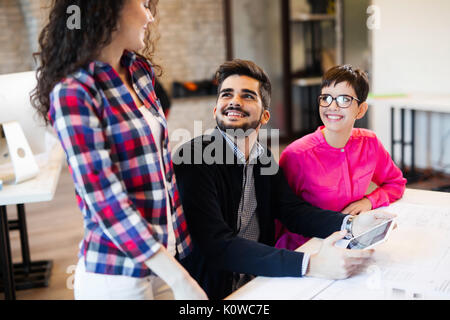 Un gruppo di giovani architetti con tavoletta digitale Foto Stock