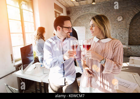 Felice giovani architetti avente pausa e bere il vino Foto Stock