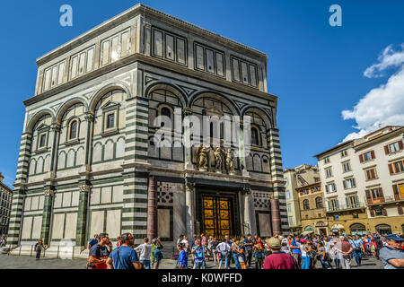 Il Battistero di Firenze di fronte al Duomo di Firenze Italia che mostra le porte di bronzo del Ghiberti come turista a godere di una giornata di sole in Toscana Foto Stock