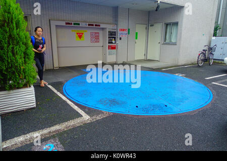 TOKYO, GIAPPONE -28 GIU 2017: donna non identificato waitting nei pressi della macchina distributrice metro di parcheggio auto per le persone utilizzano nella città di Tokyo Foto Stock