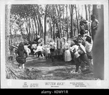 Un film scena ancora da "Riso Amaro" (1949 film italiano), che mostra un gruppo di giovani donne laughingly attraversare un fiume con alcuni di loro tirando i loro abiti per tenerlo da bagnare, 1949. Foto Stock