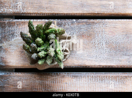 Mazzetti di asparagi giacente su di un tavolo di legno messa a fuoco selettiva Foto Stock
