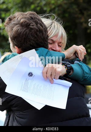 Woody Cook è abbracciato da sua madre, la televisione e la radio presenter Zoe palla dopo aver ricevuto il suo GCSE risultati a Brighton College in Brighton. Foto Stock