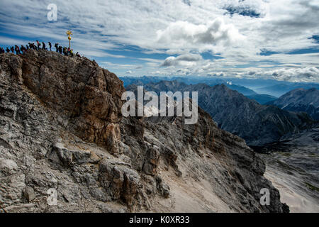 Coda di turisti per raggiungere la vetta del monte Zuspitze sulla Germania Austria confine. A 2962m è la montagna più alta in Germania. Foto Stock