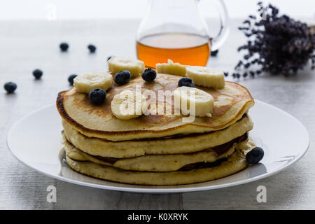 Frittelle di banane, mirtillo e miele nella luce del mattino Foto Stock
