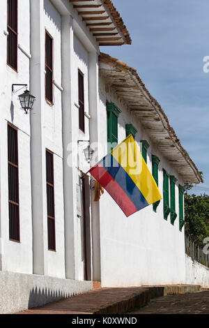 Bandiera colombiana su edificio bianco candido Foto Stock