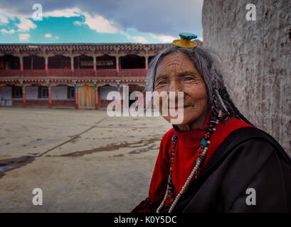 Vecchia donna tibetana in profondità nella sua preghiera. Altopiano tibetano Foto Stock