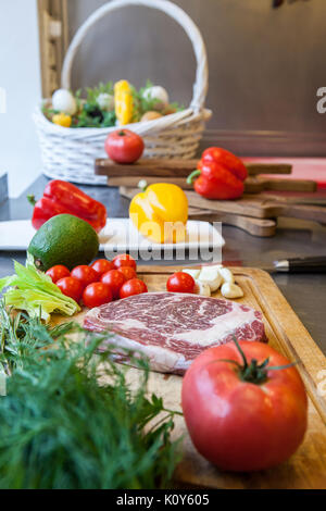 Crudo fresco di carne con verdure su una tavola di legno per la cottura Foto Stock