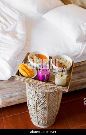 Colazione romantica per due all'interno di una camera da letto. Macchina  per il caffè e caffè bicchieri, croissant, marmellata di lamponi e meringa  fiori su legno vassoio. Romantico Foto stock - Alamy