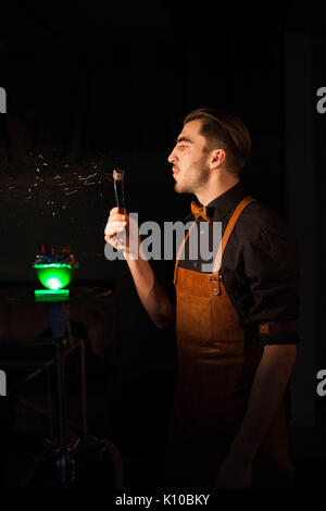 Bel giovane hookah uomo soffiando su un narghilè ember in un bar. Foto Stock