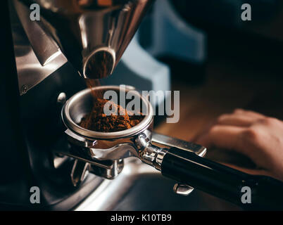 L'uomo timbratura appena macinato di caffè del mattino Foto Stock