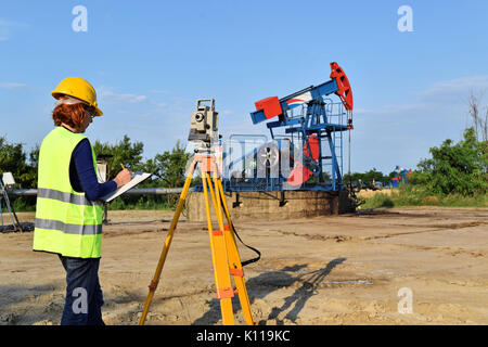 Geometra al lavoro e olio greggio pompa in background Foto Stock