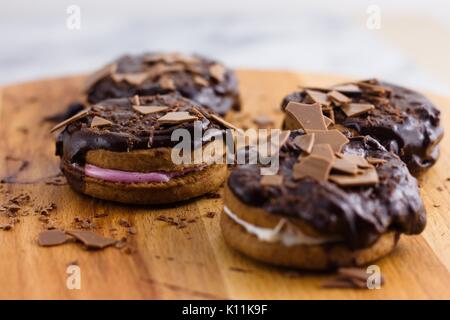 I cookie di cannella e sandwich di marshmallow sormontato da cioccolato e scaglie di cioccolato Foto Stock