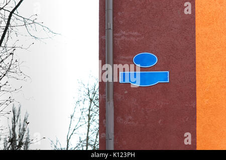 Un puntatore al nome della strada un segno sulla parete dell'edificio sulla strada Foto Stock