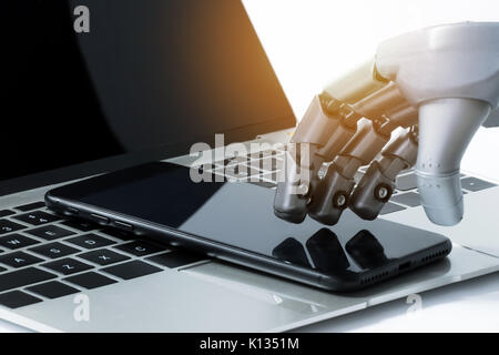 , Robotica intelligenza artificiale (AI) , robo advisor , chatbot concetto tecnologico. Dito del robot l'uso del telefono cellulare sul computer portatile con effetto flare effetto di luce. Foto Stock