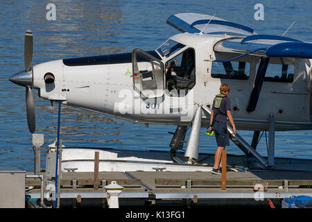 Personale di terra preparare un porto aria idrovolanti de Havilland turbo otter idrovolanti presso il porto di Vancouver centro di volo, British Columbia, Canada. Foto Stock