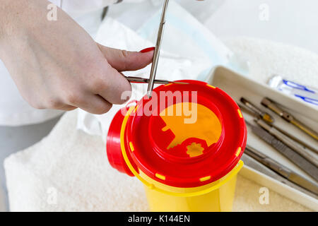 Pedicurist preparare strumenti professionali quando facendo pedicure mettendo quella utilizzata in giallo casella medico Foto Stock