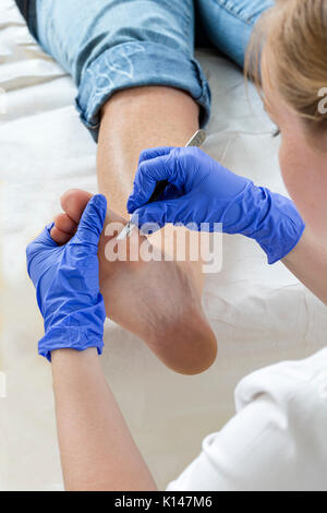 Donna podologia ricevente il trattamento- podiatrist pedicure pulizia piedi womans Foto Stock