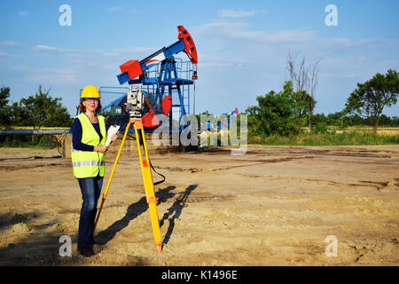 Geometra al lavoro e olio greggio pompa in background Foto Stock