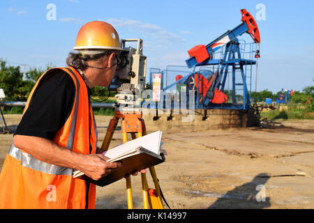 Geometra al lavoro e olio greggio pompa in background Foto Stock