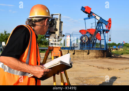 Geometra al lavoro e olio greggio pompa in background Foto Stock