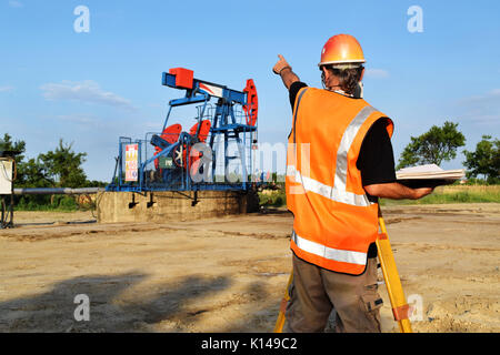 Geometra al lavoro e olio greggio pompa in background Foto Stock